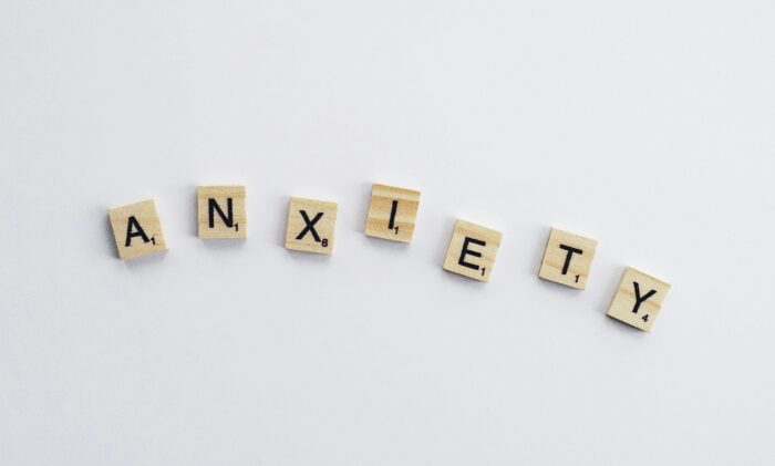 The word 'Anxiety' spelled out using wooden Scrabble tiles on a white background